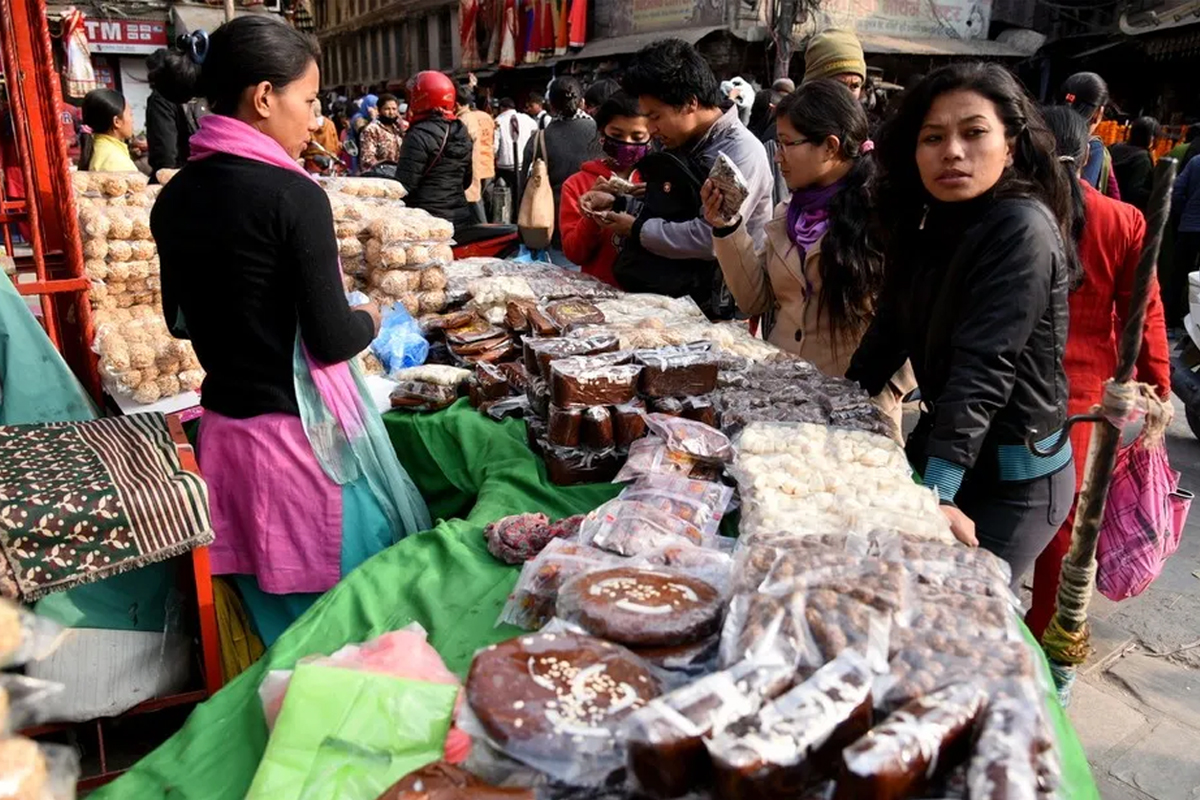 people buying sweets kept in shop 
